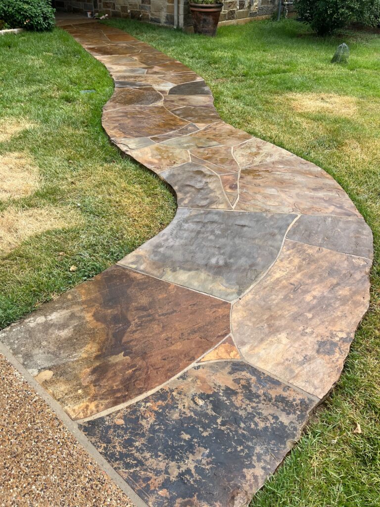 This flag stone walkway has been washed with acid and sealed properly. It has a seamless look with an organic feel with shapes that are natural instead of squares and triangles.